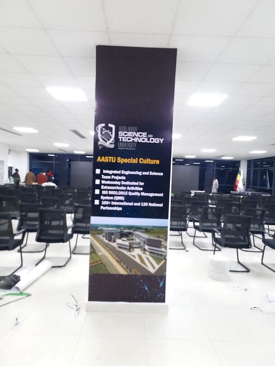 The AASTU roll-up banner in position among rows of seating before an event