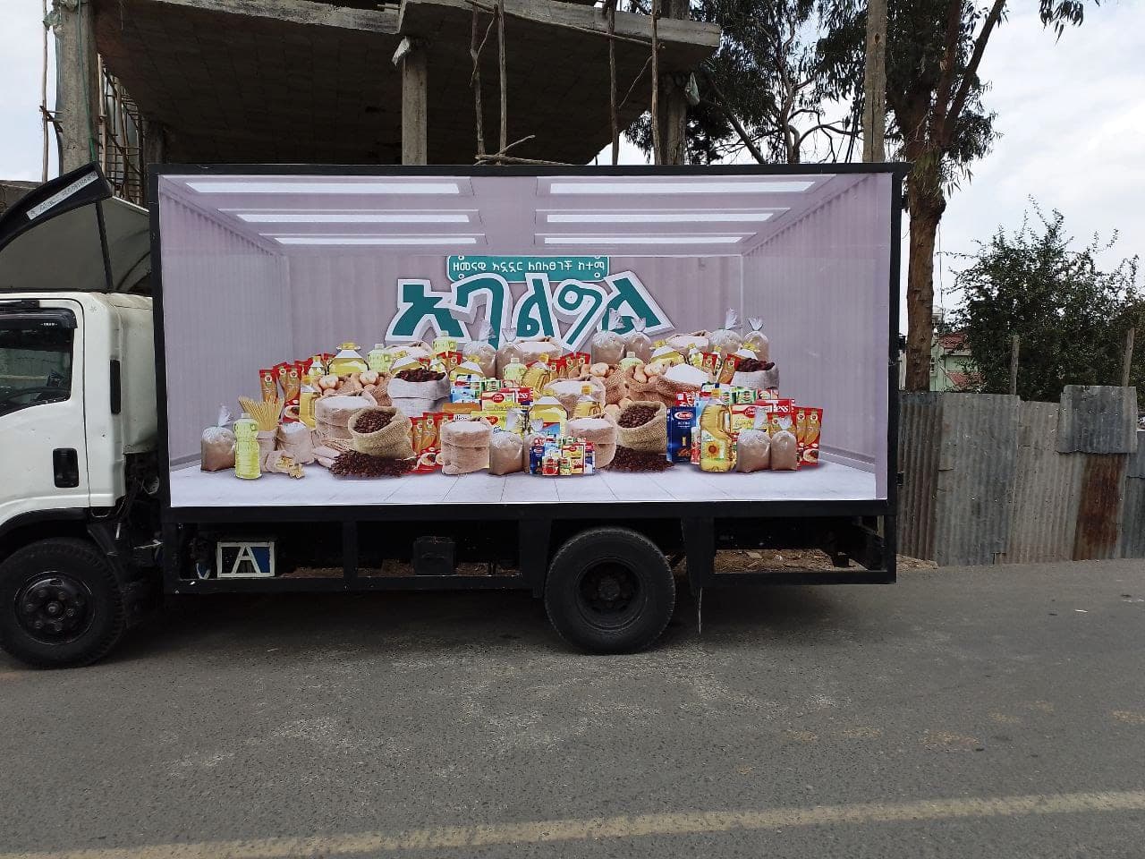 Box truck with a full-side print showing a container stacked with grocery staples under the Agelgil wordmark