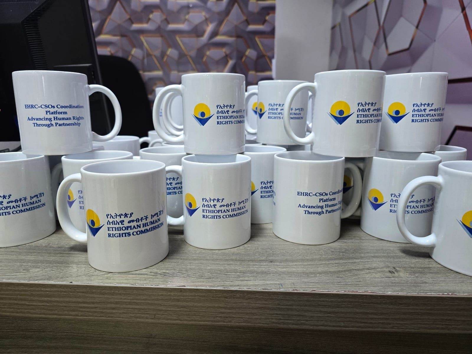 Stacked white mugs printed with the Ethiopian Human Rights Commission logo and the EHRC–CSOs Coordination Platform line