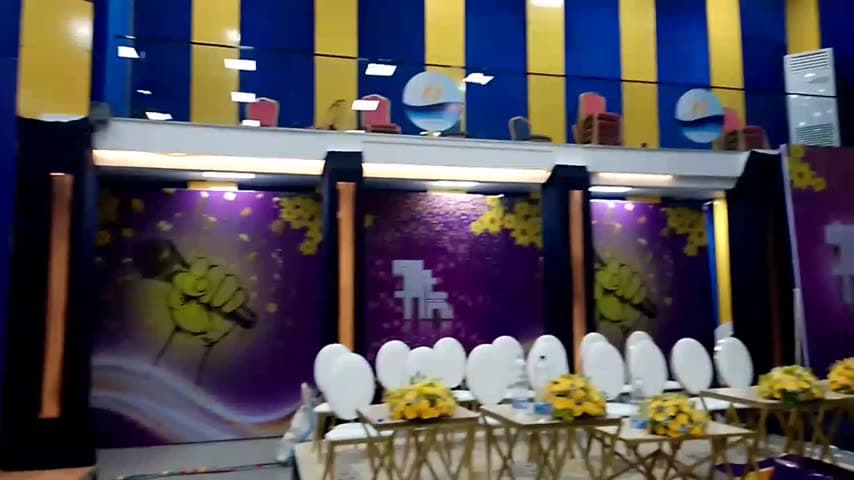 Walkthrough of the Fana Artists Award venue, past printed flower walls, the lit stage and the seated tables