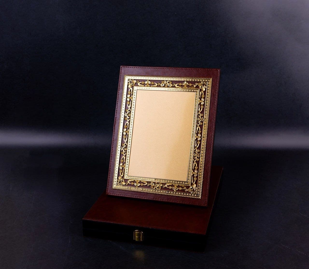 Burgundy leather presentation plaque with an ornate gold frame, standing on its fitted carrying case
