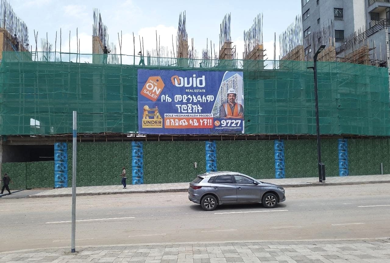 Ovid Real Estate billboard seen from across the road beside a construction site